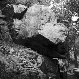 Mysterious rock formation in forested area.