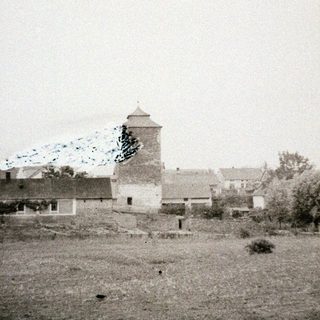 Historic village with a tower, likely in a rural setting.