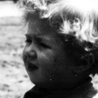Black and white photo of a young child outdoors.