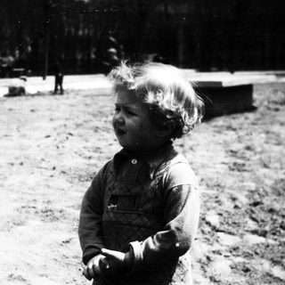 Black and white photo of a young child outdoors.
