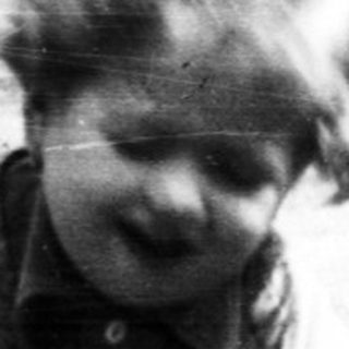 Here's a brief summary of the image: Child playing in dirt, possibly digging or squatting.