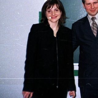 Three people pose in front of a blackboard.