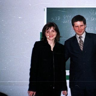 Three people pose in front of a blackboard.