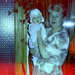 Woman holds baby in a warmly lit interior.