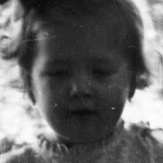 Here's a brief summary of the image: Black and white photo of a young child walking on a path.