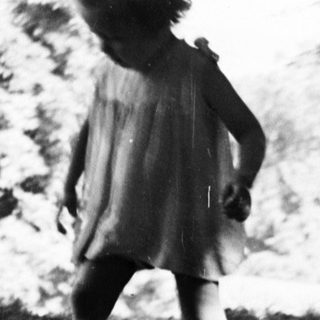 A young girl walks on a path in nature.