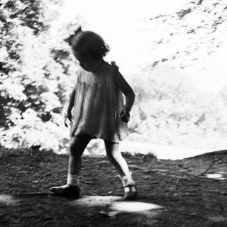 A young girl walks on a path in nature.