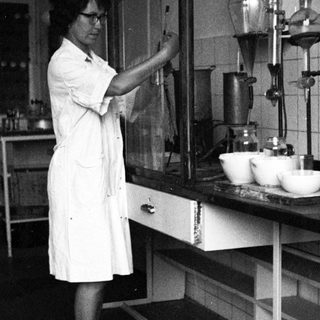 Scientist working in a lab, using lab equipment.