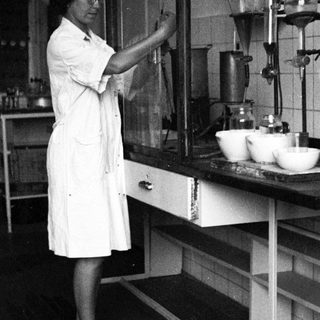 Scientist working in a lab, using lab equipment.