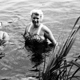 Two people swimming in a body of water.