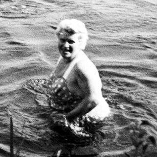 Two children are swimming in a body of water.