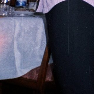 Woman holding baby in a dining room setting.