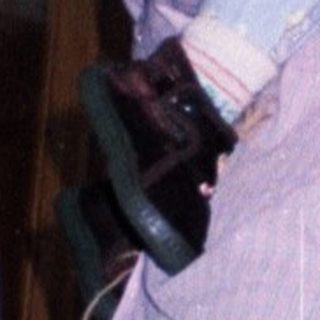 Woman holding baby in a dining room setting.