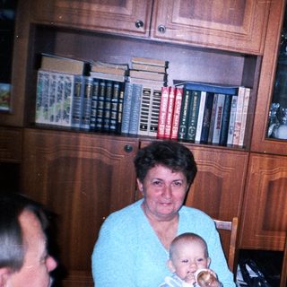 Woman holding baby at a table with family.