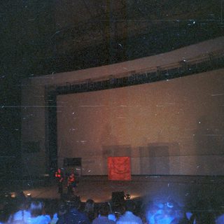 Concert stage with a large screen and audience.