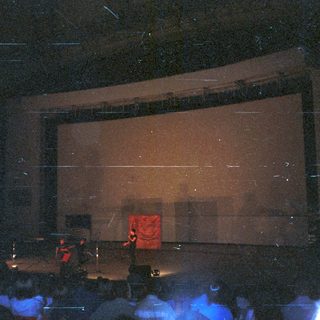 Concert stage with a performer visible on screen.