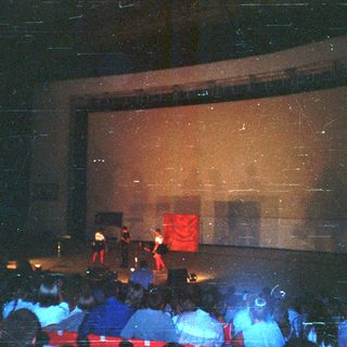 Audience seated, watching a performance on stage.