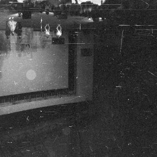Stage with performers, illuminated by spotlights, in a dark theater.