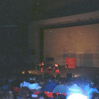 People on stage performing for an audience in a theater.