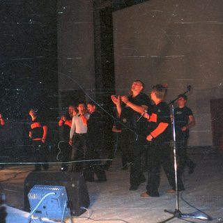 Group of people on stage with a sign and microphone.