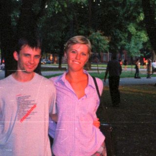 Couple posing outdoors in a park-like setting.