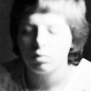 Faded black and white portrait of a young person.