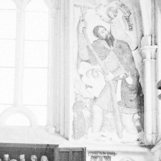 People view a sculpture within an ornate church interior.