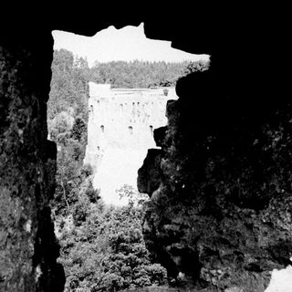 Waterfall viewed through a natural rock archway.