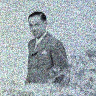 Man and child visible through a window, blurred foliage.