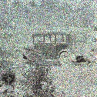 Here's a brief summary of the image: Blurred view of a building and trees in a landscape.