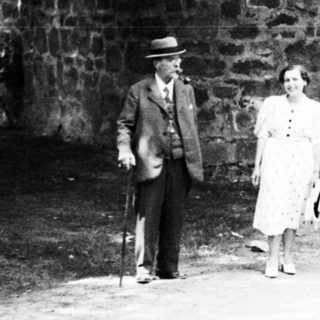 People stand near an arched stone structure.