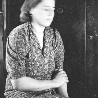 Black and white portrait of a woman in a patterned dress.
