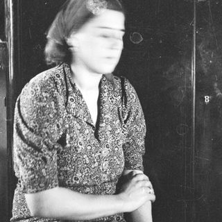 Black and white portrait of a woman in a patterned dress.