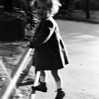 Young girl runs, blurred motion, outdoor setting.