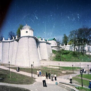 Fortress walls and people strolling in a park setting.