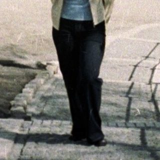 Woman walks towards a church with golden domes.