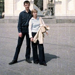 Couple poses in front of an ornate monument.