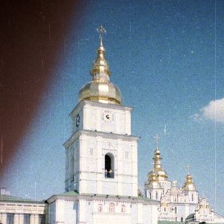 Woman stands before a large, ornate church complex.
