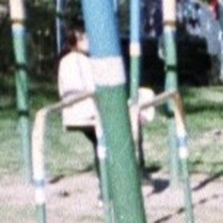 Man holding a child on a playground, outdoors.