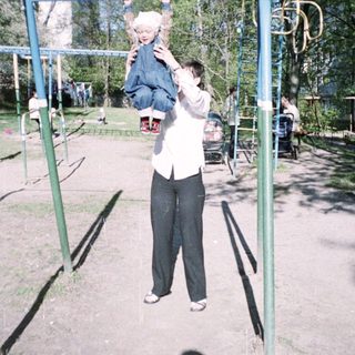 Man holding a child on a playground, outdoors.