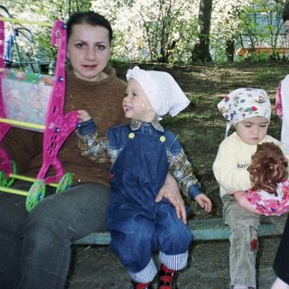 Two women and two young children sit on a bench.