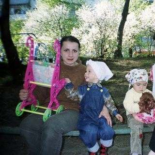 Two women and two young children sit on a bench.