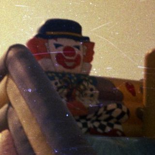 Man stands near a colorful slide with clown features.
