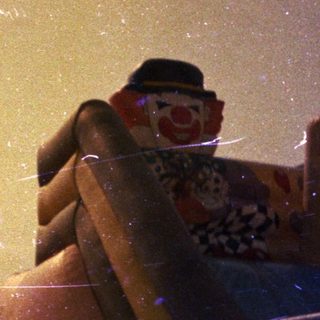 Vintage photo shows a clown-themed inflatable slide and flags.