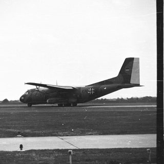German transport aircraft sits on an airfield runway.