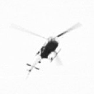 Here's a brief summary of the image: Helicopters flying in formation across a field.