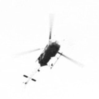 Here's a brief summary of the image: Four helicopters fly in formation across a cloudy sky.