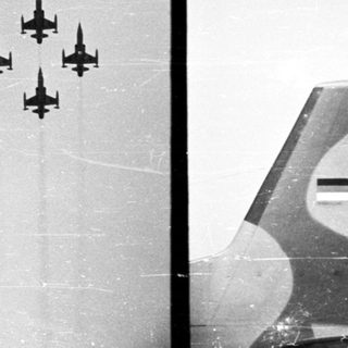 Here's a brief summary of the image: Four airplanes perform an aerial display in the sky.