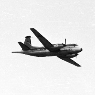 Aircraft performs aerial maneuvers against a bright sky.