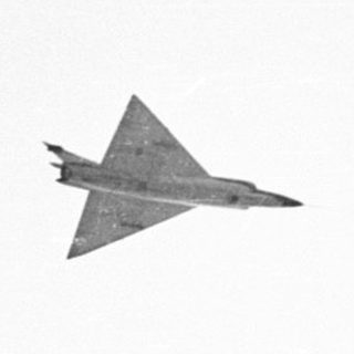 Fighter jet flying in a white sky.